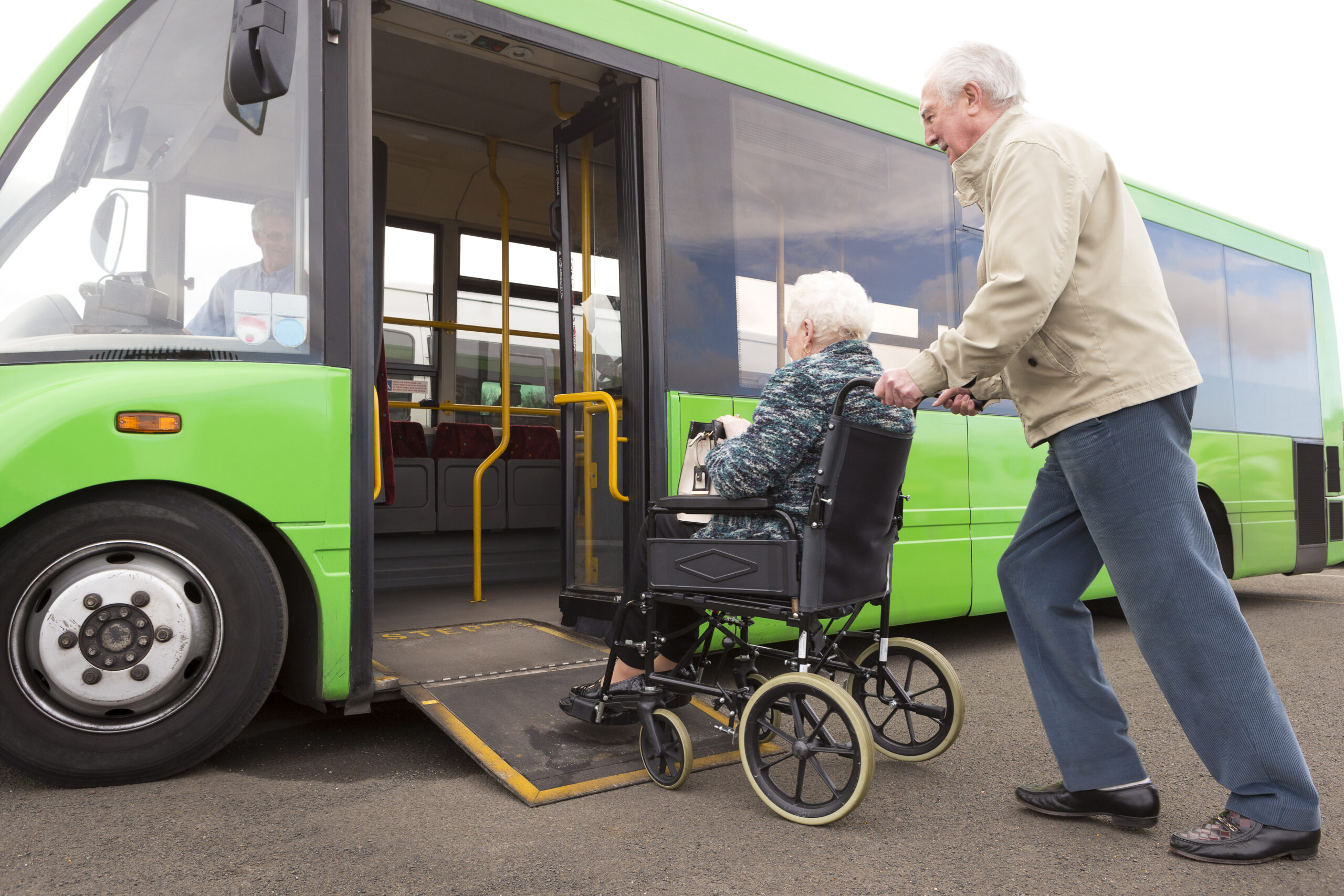 Senior Couple Getting on Bus Via Wheelchair Ramp
