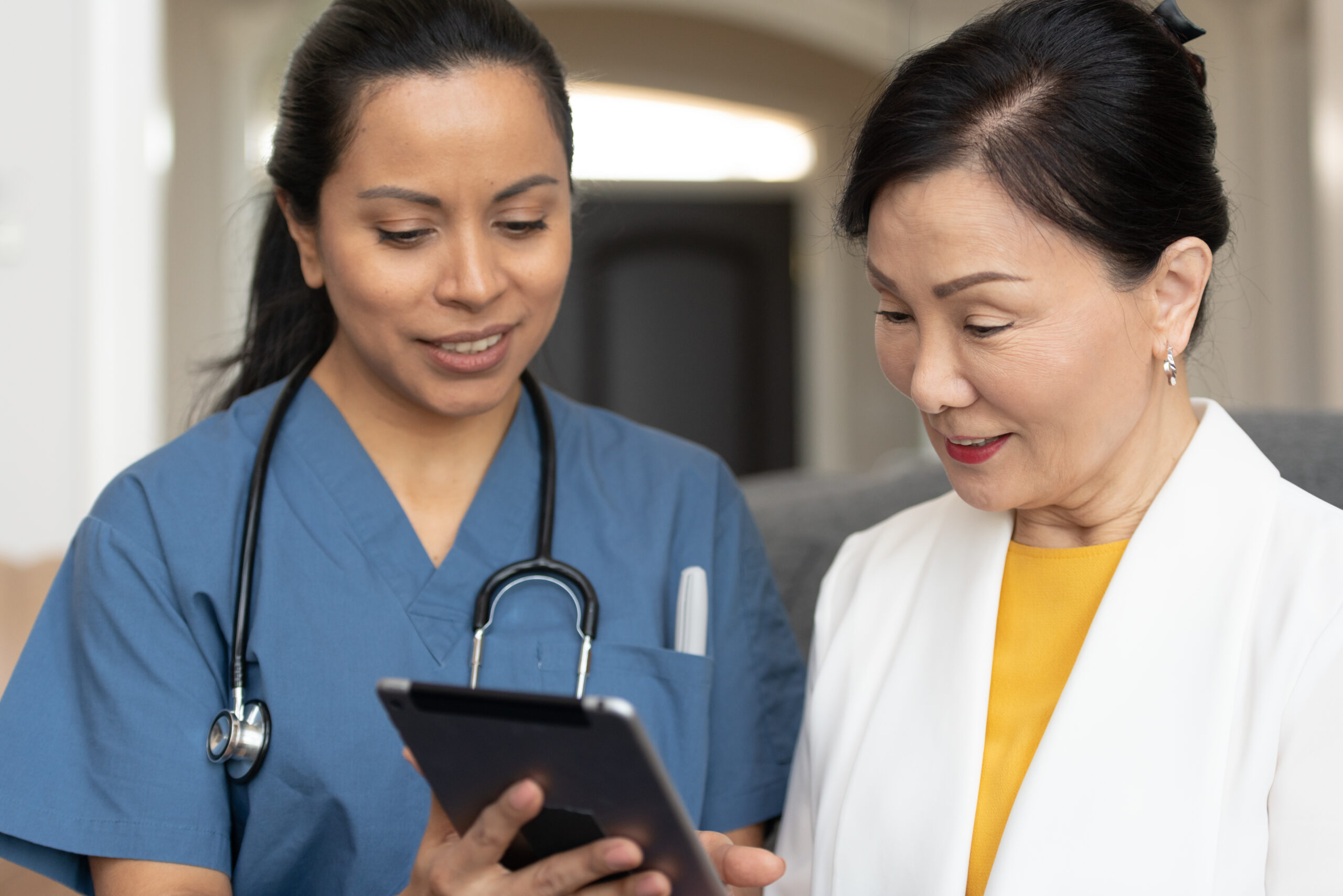 Female doctor using tablet with senior patient