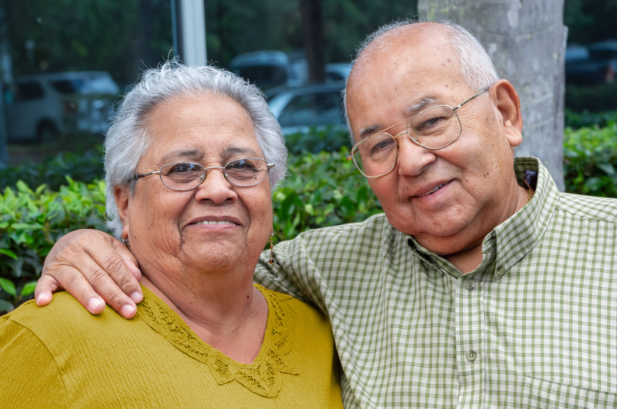 Smiling hispanic senior couple posing looking at the camera